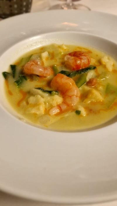 Zuppa di cavolfiore, gamberi viola, cavolo verde, pak-choi e arachidi